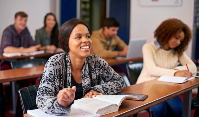 Furthering their education. Shot of a happy student paying attention in class.