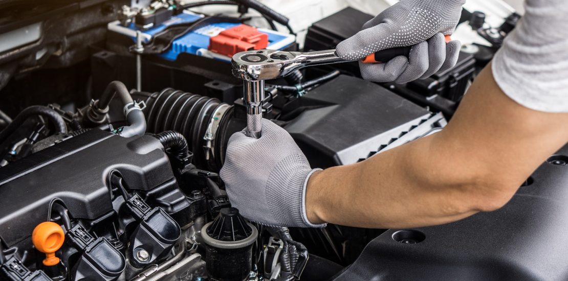 Mechanic man working on the engine of the car in the garage.Car service and maintenance.